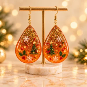 Handmade Christmas resin teardrop earrings with Christmas trees, snowflakes and gold glitter by Mehreen & Miral.