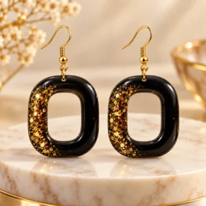 Handmade black and gold glitter resin geometric drop earrings for women by Mehreen & Miral.