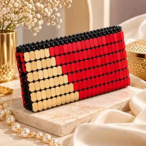 Beadelle handmade red and beige beaded clutch bag for women with black bead detailing and zipper closure.